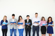 © Africa Studio - Group of people reading books while standing near light wall