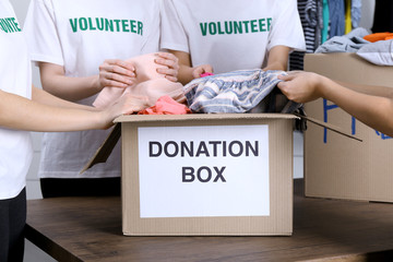 Wall Mural - Female volunteers preparing donation box with clothes