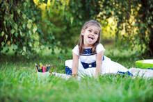 Маленькая девочка рисует в парке на открытом воздухе