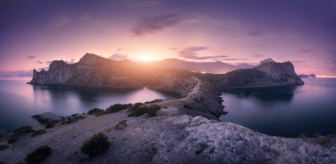 Wall Mural - Beautiful mountains against colorful cloudy sky at sunset. Landscape with rocks, sea, mountain trail, forest, purple sky and city lights in summer. Nature and travel. Blurred clouds. Panoramic view