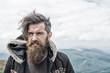 © be free - bearded handsome serious man on mountain top