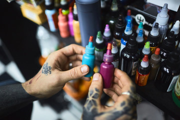 Wall Mural - Tattooist choosing paints for new work