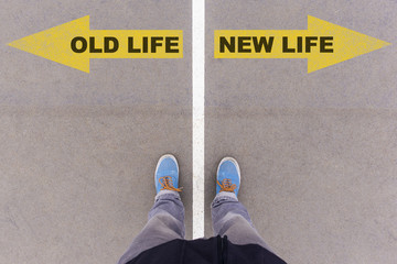 Old vs new life text arrows on asphalt ground, feet and shoes on