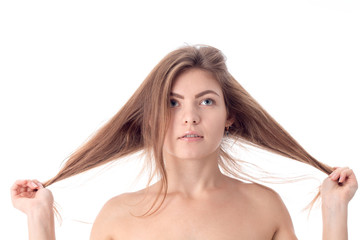 Wall Mural - young girl without makeup keeps his hair with both hands isolated on white background