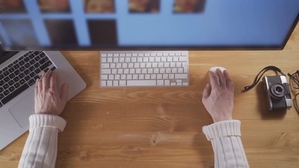 Male hands using laptop computer and mouse to search pictures on the computer screen