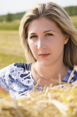 Beautiful girl with a soft look on the background of straw