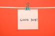 Pink paper sheet on the string with text “Good Job”