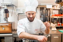 Portrait Of A Chef Cook In Uniform With Big Cooker At The Restaurant Kitchen