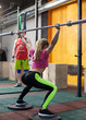 © zdyma4 - Athletic woman is squatting with a barbell under the trainer's supervision