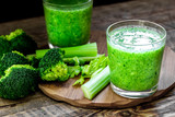 Fototapeta Kuchnia - Green vegetable smoothie in glass at wooden background
