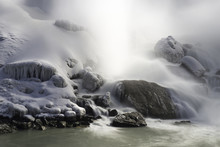 Snow Covered Rocks At Bottom Of A Waterfall In Winter, Tranquil