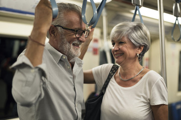 Senior couple traveling inside train subway