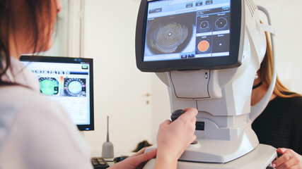 High technology health care - ophthalmologist in eyes clinic working with patient by modern computer technology