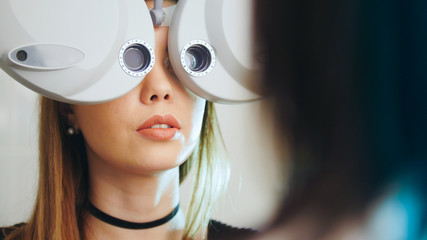 Ophthalmology clinic - woman checks vision by modern equipment - eyes exam