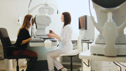 Optician with tonometer and patient at eye clinic, diagnostic