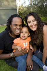 Happy biracial family smiling at a park.