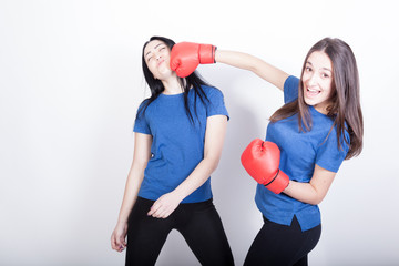 Two cheerful young women are boxing. Sport women having fun.