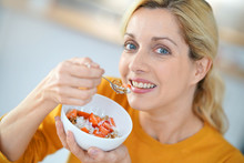 Portrait Of Blond Middle-aged Woman Eating Cereals