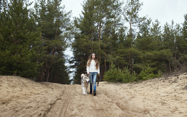 Red-haired girl with freckles walking with Husky dog in autumn f