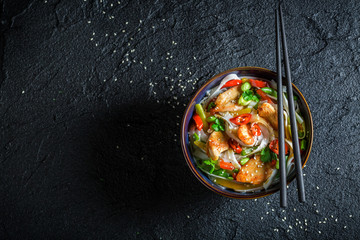 Hot noodle in dark bowl with chopsticks