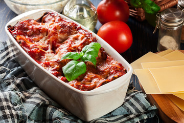 Wall Mural - Hot tasty lasagna with spinach in ceramic casserole dish