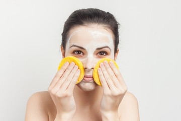 two round sponge and a woman with a white mask on her face