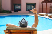Man In A Hat Lying On A Lounger By The Pool Sun Day