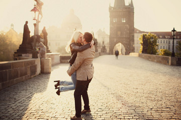 young woman and man kiss each other on the street