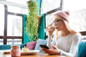 Wall Mural - Gorgeous young lady sitting in cafe and drinking coffee.