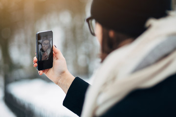 Wall Mural - Portrait beautiful girl in black hat and coat with scarf make selfie