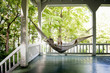 © Cavan Images - Woman relaxing with book on hammock