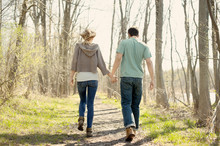Couple Walking Through Forest Path