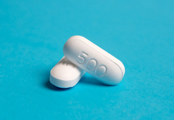 Closeup two white medicine and pills on blue sky background