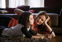 Daughter (8-9) Lying With Mother On Rug