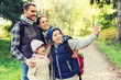 © Syda Productions - family with backpacks taking selfie by smartphone