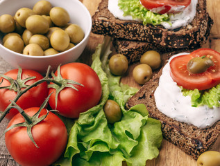 Wall Mural - Sandwiches with healthy rye bread, cheese cream, tomatoes, green olives 