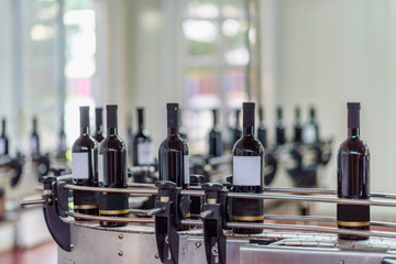 Red wine bottling and sealing conveyor line at winery factory