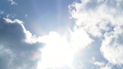 Wall Mural - Bright and blue sky cloudscape with sun shining as clouds pass on by.