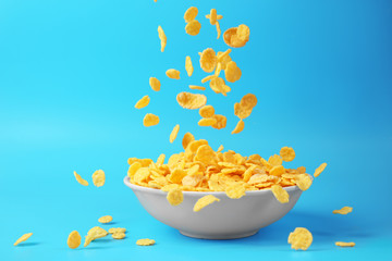 Wall Mural - Bowl with corn flakes on blue background