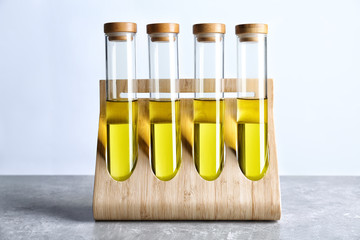 Wall Mural - Tubes with olive oil in wooden stand on table