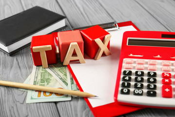 Sticker - Wooden cubes with word TAX and calculator on table