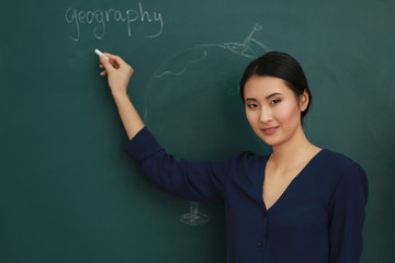 Wall Mural - Portrait of Asian female teacher on blackboard background