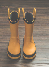 Yellow Rain Boots On Wooden Floor