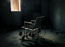 Old Wheelchair Was Forsaken In Old Room. Lonely And Scary Concept. Halloween Theme