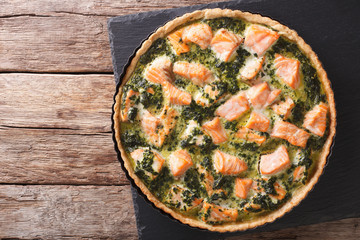 Canvas Print - Tasty Savory Tart with salmon and spinach in the dish for baking close-up. horizontal top view