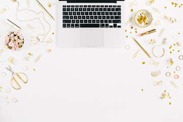 Beauty blog background. Workspace with laptop, gold style feminine accessories. Golden tinsel, scissors, pen, rings, necklace, bracelet on white background. Flat lay, top view office table desk.