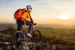 © Aleksey - low angle view of cyclist standing with mountain bike on trail at sunset