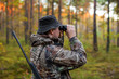 © Kaspars Grinvalds - Hunter observing forest with binoculars