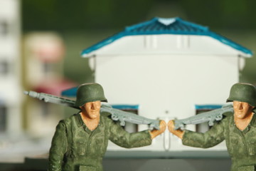 The miniature soldier among the blurred building background scene represent the miniature plastic toy figure model concept related idea.