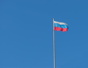 Russian flag against blue sky.